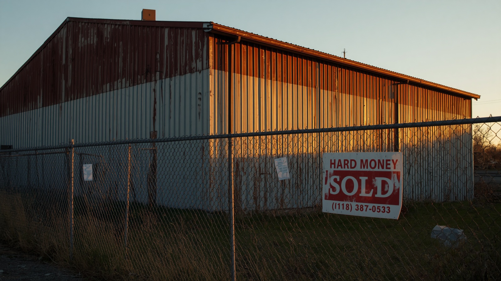 A weathered industrial warehouse photographed at the golden hour